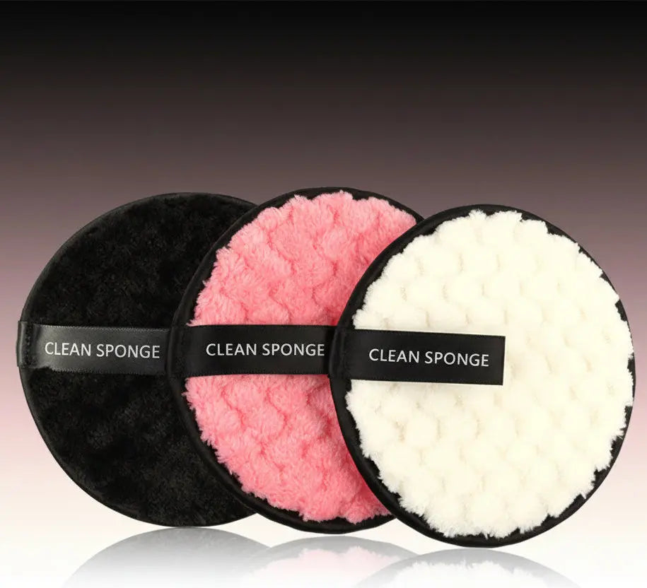 Set of three round clean sponges in black, pink, and white with textured surfaces