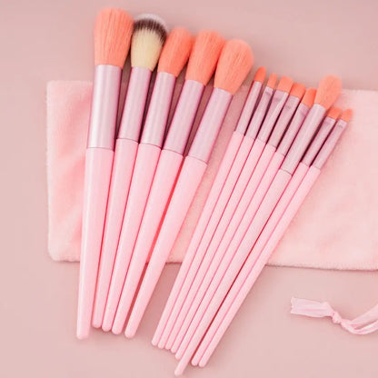 Set of pink makeup brushes with soft bristles on a pink cloth and pale pink background