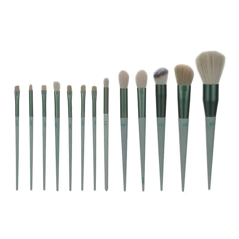 Set of twelve green-handled makeup brushes with various brush head shapes and sizes on white background