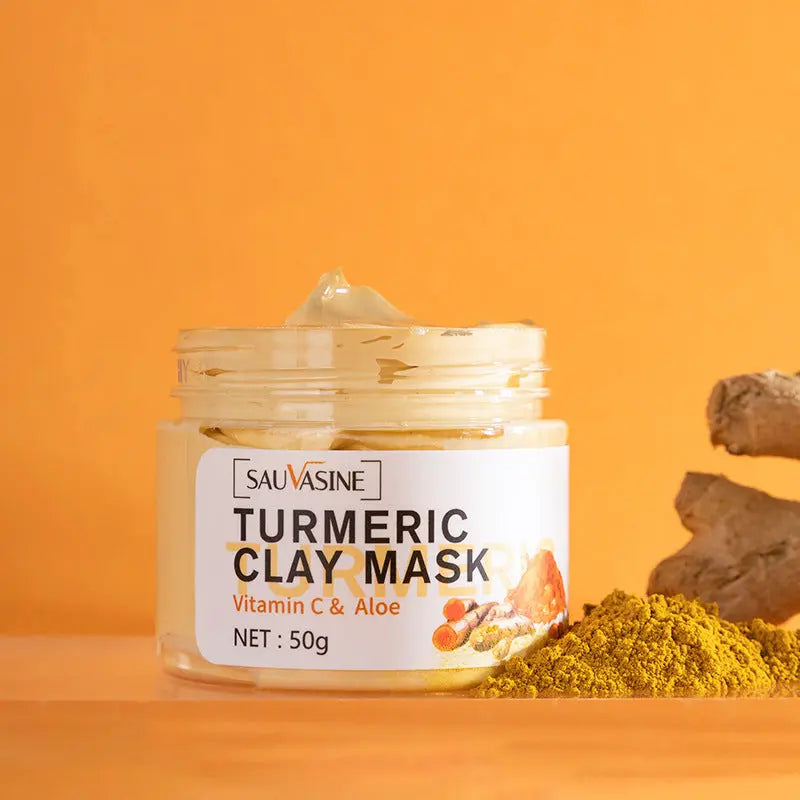Sauvasine turmeric clay mask with vitamin C and aloe in clear jar beside turmeric powder and root